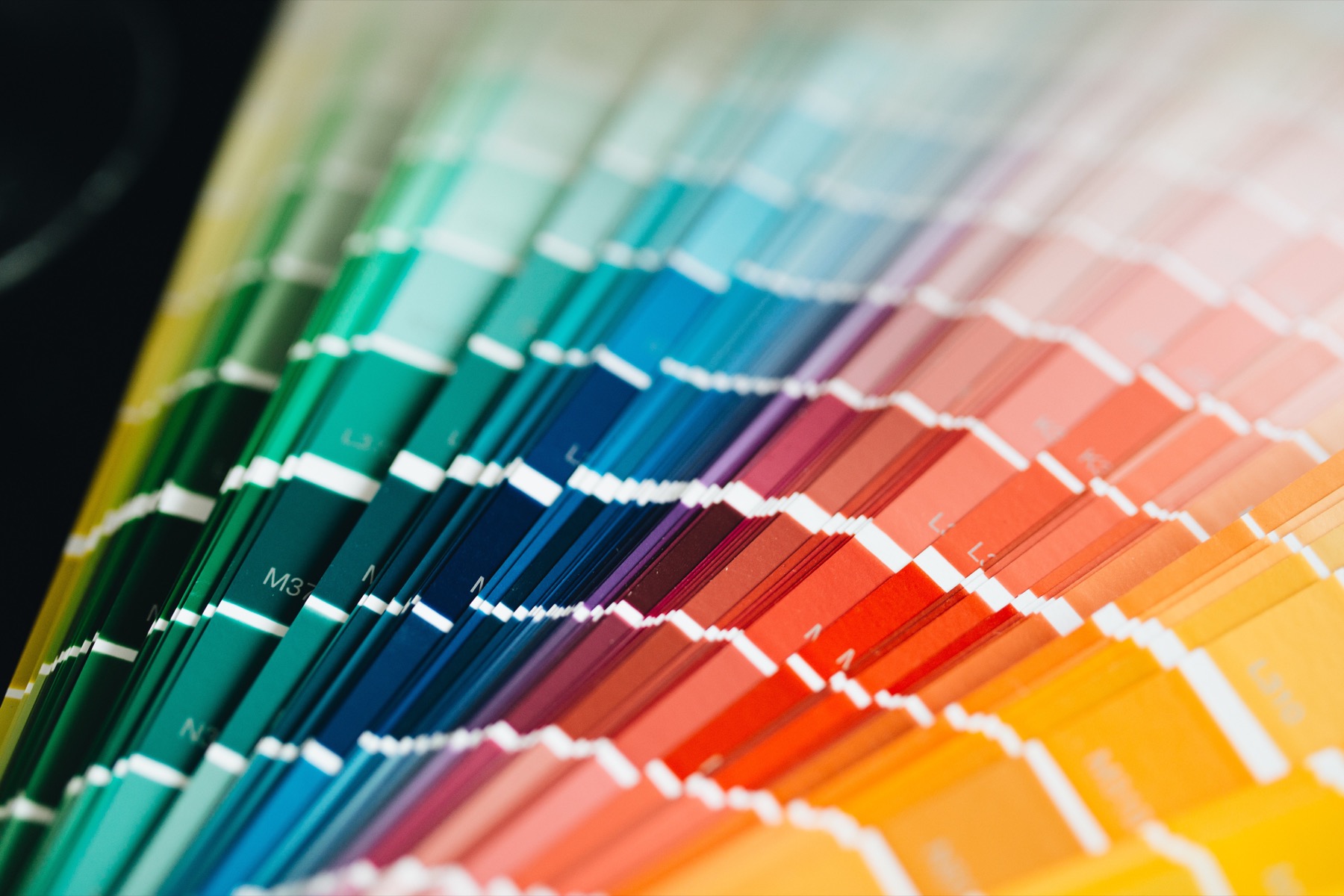 A fan of printed color swatches arranged across the spectrum